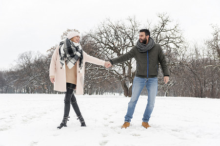 恩爱夫妻摄影照片_恩爱夫妻享受在公园里雪