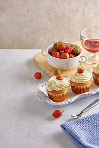 口感芬芳，带有草莓味的纸杯蛋糕，白底特写上温和的奶油