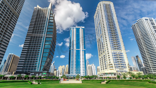 位于阿联酋迪拜的朱美拉湖塔 timelapse 的住宅建筑。猪苓汤是一个大发展包括79个塔与3个人工湖和公园。从公园看蓝色多云的天空