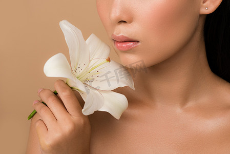 美丽的赤裸裸的亚洲女孩抱着米色白色百合花的剪影