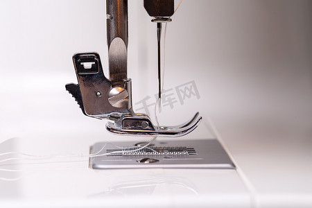 针线活摄影照片_把缝纫机特写下来针线活和裁剪的概念