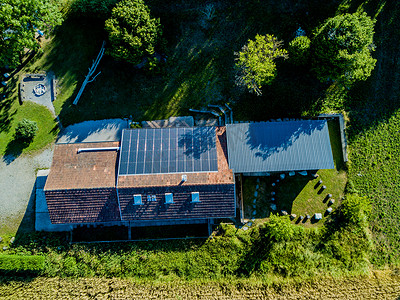 欧洲农场建筑屋顶光伏的空中景观。太阳能发电用建筑集成光伏发电.