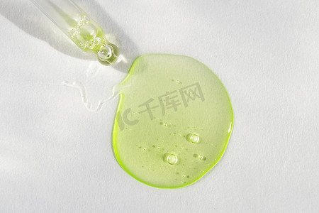 带有绿色液体透明质酸和白色背景的皮佩特。化妆品和保健概念特写