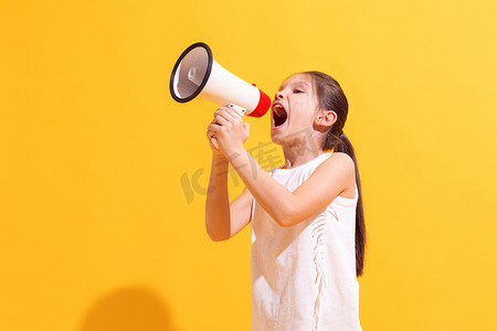 News, sales. Emotional cute girl, kid shouting at megaphone isolated on bright yellow background. Concept of children emotions, holidays, vacation, fashion, beauty, ad