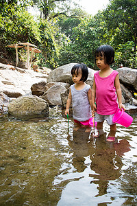 亚洲小的中国女孩在小河里玩耍