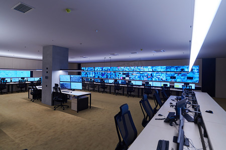 大型现代化安全系统控制室内空旷，多台工作站，监控室内有安全数据中心空置的办公室、办公桌和主闭路电视安全数据中心的椅子