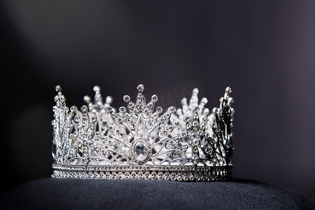 fabric摄影照片_Diamond Silver Crown for Miss Pageant Beauty Contest, Crystal Tiara jewelry decorated gems stone and abstract dark background on black velvet fabric cloth, Macro photography copy space for text logo