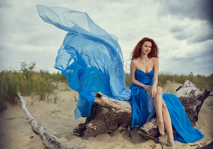 夏天在海滩上穿上蓝裙子的女人