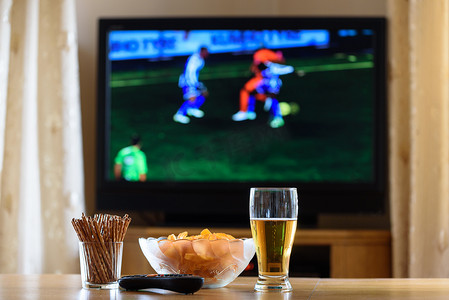 television, TV watching (football, soccer match) with snacks lyi