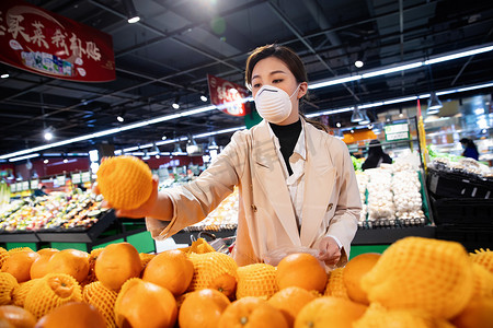 水果超市促销摄影照片_戴口罩的青年女人在超市挑选水果