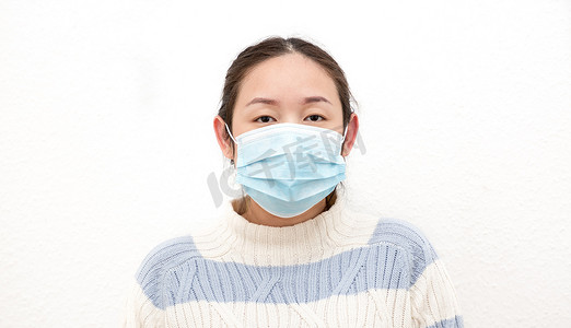 一个年轻的亚洲女人戴着面具以防止细菌、有毒烟雾和灰尘的形象。预防白背景空气中的细菌感染