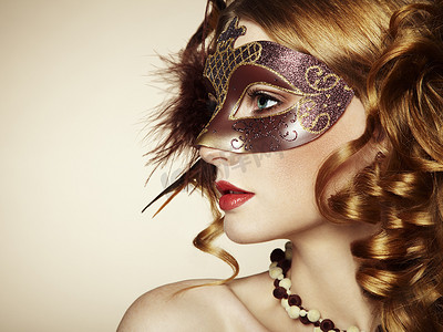 神秘女子摄影照片_美丽的年轻女子在棕色神秘威尼斯面具