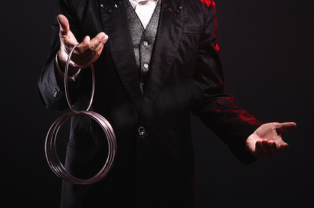 绅士魔术师胡子摄影照片_魔术师用金属戒指表演魔术。操纵道具. 