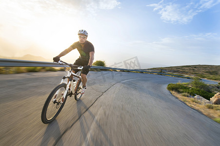 骑自行车的人男子骑山地自行车在晴朗的一天的山路上