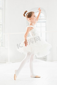 跳舞的孩子们摄影照片_芭蕾舞女演员的小姑娘兔兔。在一个白色的工作室跳舞古典芭蕾的可爱孩子.