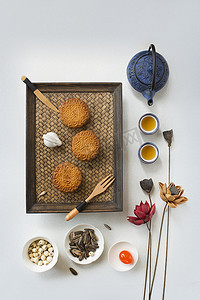 质感白色质感摄影照片_平平静静地躺在中秋节的月饼茶、食品和饮料的白色质感背景下.