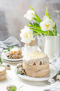 传统的复活节蛋糕在一个轻木背景。装饰着鲜花。旁边是一个小蛋糕, 鹌鹑蛋和花。切一块蛋糕。复活节.庆祝.春天.乡村风格