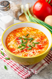 聚焦的摄影照片_传统的中国鸡蛋滴汤, 西红柿和葱在碗上灰石背景。选择性聚焦.