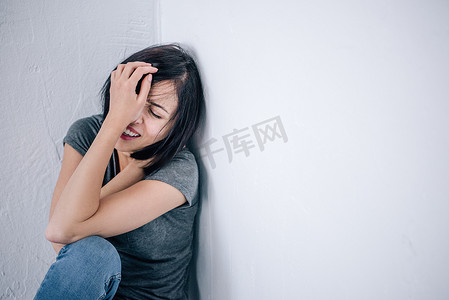 哭脸摄影照片_心烦意乱的孤独的黑发女人哭和覆盖脸在家里