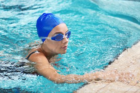 水池摄影照片_游泳的年轻运动妇女在水池