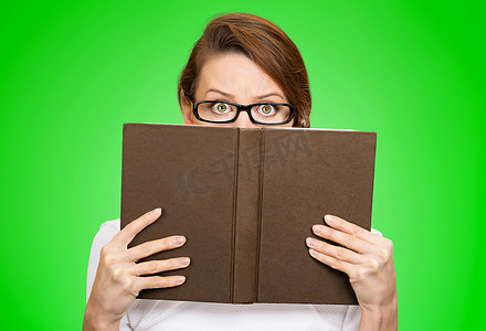 戴着眼镜，她的脸庞在本书后面的女人