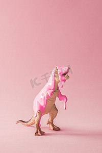 粉红色油漆滴在恐龙玩具, 创意极小的概念 
