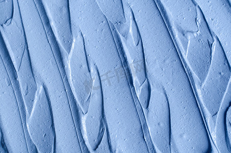 浅蓝色膨润土面部黏土（海藻酸钠面膜，面霜，身体包裹）质感闭合，选择性聚焦。带有笔划的背景摘要. 