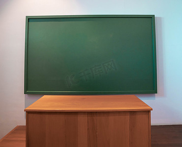 教室里的课桌和空白绿色黑板.
