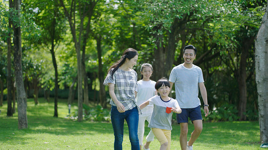 中国家庭微笑和一起漫步在公园 