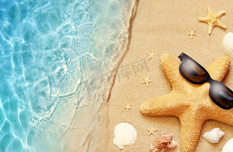 沙滩背景摄影照片_夏季沙滩背景。戴着太阳镜和大海的海星夏季概念.