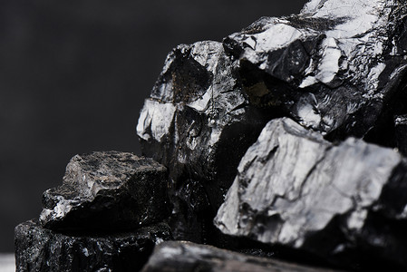 天然煤在黑色背景查出特写镜头。天然矿产资源的提取.