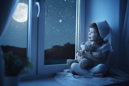 满天飘雪摄影照片_儿童小女孩在窗口做梦和欣赏满天星斗的天空