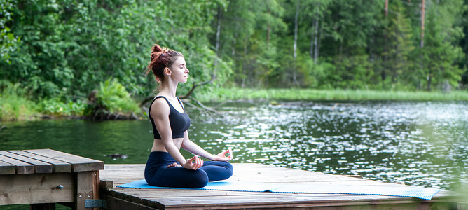 年轻女孩在湖上的自然中练习瑜伽。女性 h