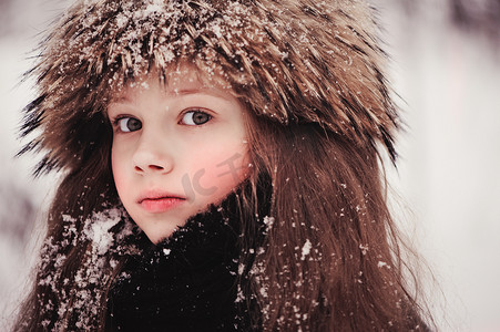 快乐的梦幻孩子小女孩走在下雪的冬天森林