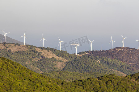 西班牙安达卢西亚树木繁茂的山峰上的风力涡轮机 