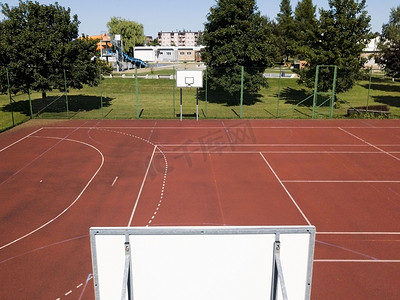 体育教育摄影照片_现代篮球场在小学的庭院。多功能儿童游乐场用人工表面围栏栅栏。儿童和青少年的体育教育场所.