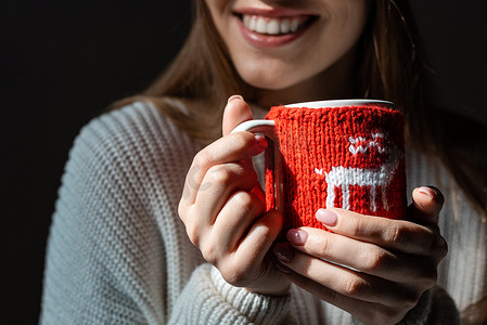 微笑的女人举着圣诞杯咖啡的剪影