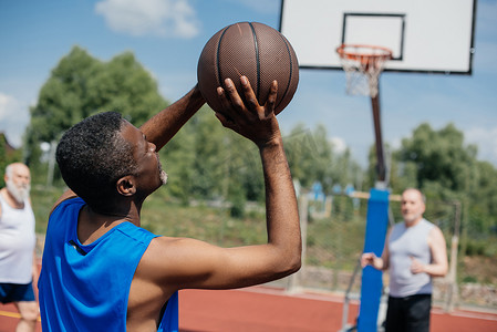 多种族老年人在操场上打篮球在夏天天