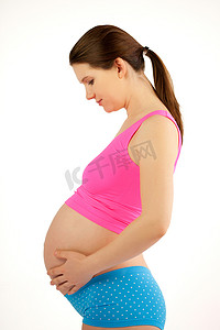 粉红色孕妇摄影照片_孕妇持腹部粉红色和蓝色.