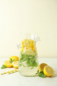 质感白色质感摄影照片_将柠檬水、柠檬和稻草放在白色质感桌子上