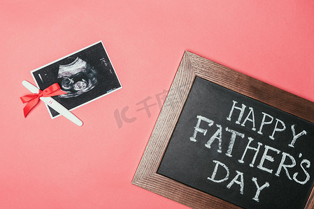 快乐父亲日的顶面视图黑板, 超声波扫描和妊娠测试用丝带隔离粉红色