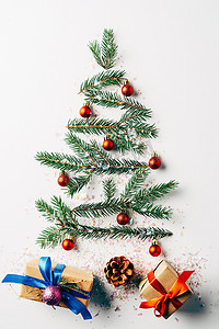 绿色松树分行的顶部视图装饰作为节日圣诞树与礼物和闪光的白色背景
