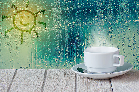 水滴在玻璃窗口和太阳符号黑色咖啡杯子