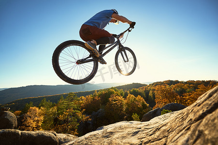 职业运动员骑自行车在岩石上跳上试车