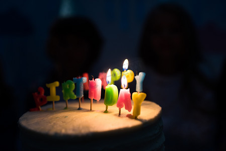 黑暗房间摄影照片_生日蛋糕，点着蜡烛