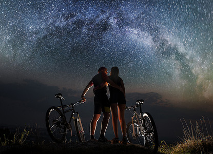 山地自行车在晚上在星空下与几个骑自行车的人