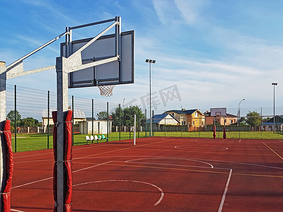 体育教育摄影照片_现代篮球场在小学的庭院。多功能儿童游乐场用人工表面围栏栅栏。儿童和青少年的体育教育场所.