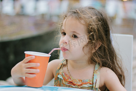 小孩子摄影照片_小孩子在咖啡馆或餐馆喝可乐.