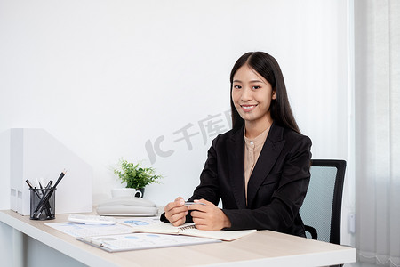 亚洲女商人坐在她们的办公桌前，计算显示她们投资成果的财务图表，规划一个成功的办公室业务增长过程.