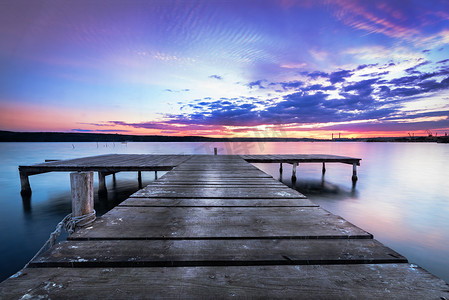 木码头上水蓝色的湖日落和光滑思考